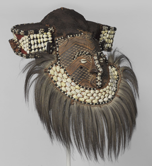 Kuba artist. Mask (Mwaash aMbooy), late 19th or early 20th century. Rawhide, paint, plant fibers, textile, cowrie shells, glass, wood, monkey pelt, feathers, 22 × 20 × 18 in. (55.9 × 50.8 × 45.7 cm). Brooklyn Museum; Robert B. Woodward Memorial Fund, 22.1582. (Photo: Brooklyn Museum)